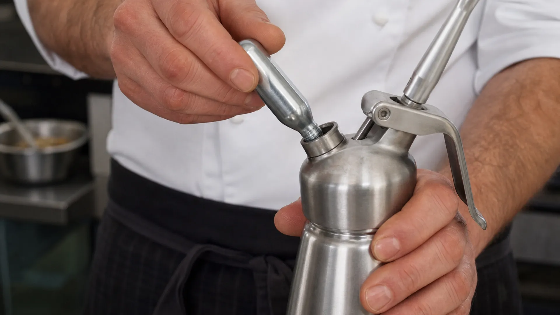 Chef inserting an 8g N2O cream charger into a whipped cream dispenser charger holder